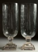 A PAIR OF CUT GLASS STORM LAMPS on square bases. 15ins high.