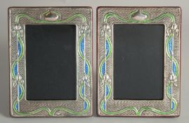 A PAIR OF SILVER AND ENAMEL PHOTOGRAPH FRAMES. 7.5ins X 5.5ins.