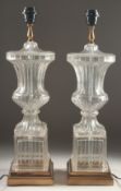 A GOOD PAIR OF GLASS URN SHAPED LAMPS AND BASES 2ft high.