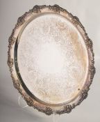 A CIRCULAR ENGRAVED SILVER PLATED TEA TRAY with cast fruiting vine edge. 15ins diameter.