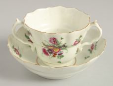 AN 18TH CENTURY WORCESTER POLYCHROME CHOCOLATE CUP AND SAUCER painted with sprays and sprigs of