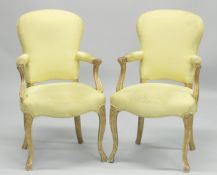 A PAIR OF FRENCH HEPPLEWHITE GILDED ARMCHAIRS with yellow padded backs and seats.