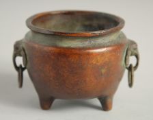 A SMALL CHINESE BRONZE CIRCULAR CENSER with elephant handles. 2.25ins diameter.