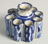AN EARLY ISLAMIC POTTERY EIGHT DIVISION INKWELL. 3.5ins diameter.