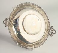 A CIRCULAR SILVER TWO HANDLED FRUIT BOWL with ribbon motif handles. 8.75ins diameter. Chester