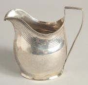 A GEORGE III SILVER CREAM JUG with reeded edge and engraved crest. London 1801 maker A & G BURROWS.