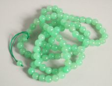 A STRING OF JADE BEADS 20ins long.