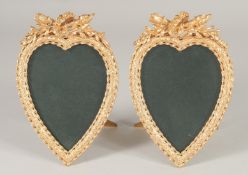 A GOOD PAIR OF GILT BRONZE HEART SHAPED EASEL PHOTOGRAPH FRAMES. 7ins x 4ins.