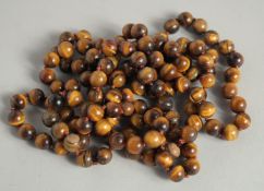 A STRING OF TIGER'S EYE BEADS. 50ins long.