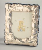 A SILVER BABY'S PHOTOGRAPH FRAME with teddy bear, ducks, train etc. 5.25ins x3.5ins in a blue box.