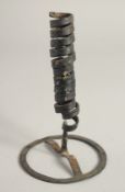 AN EARLY METAL CANDLESTICK. 7ins high.
