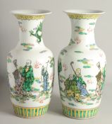A PAIR OF CHINESE PORCELAIN VASES painted with people. 1ft 5ins high.
