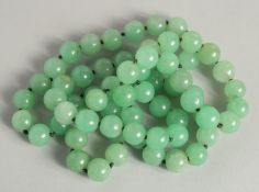 A STRING OF JADE BEADS 34ins long.