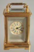 A MINIATURE BRASS CARRIAGE CLOCK 2ins high.