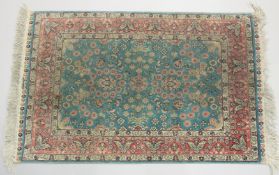 A GOOD SMALL SHIRVAN SILK RUG turquoise ground with floral decoration in a pink ground border.