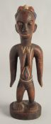 A CARED WOOD TRIBAL FEMALE FIGURE with old pigment. 10.5ins high.
