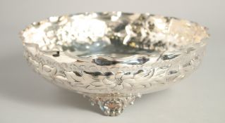 A CONTINENTAL SILVER PLATED CIRCULAR HAMMERED BOWL supported on three shell feet. 9.5ins diameter.