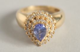 A 14CT GOLD TANZANITE AND DIAMOND TEARDROP RING.