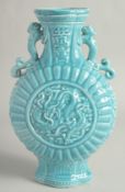 A CHINESE BLUE GLAZE TWIN HANDLED MOON FLASK with a central relief dragon motif. 33cm high.