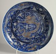 A LARGE CHINESE BLUE GROUND PORCELAIN DRAGON DISH, painted with a central dragon and the pearl of