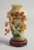 A CHINESE RELIEF CARVED JADE VASE mounted to a hardwood base, the side carved with cherry blossom,