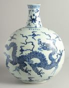 A VERY LARGE CHINESE BLUE AND WHITE PORCELAIN MOON FLASK painted with a large dragon to either side,
