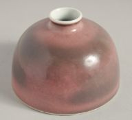 A CHINESE PEACH-BLOOM GLAZE PORCELAIN CIRCULAR INK POT, six-character mark to base, 12cm diameter.