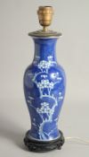 A CHINESE BLUE AND WHITE PORCELAIN PRUNUS VASE / LAMP, mounted to a wooden base, 42cm high overall.