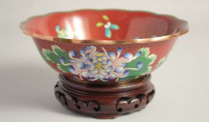 A GOOD CHINESE RED GROUND CLOISONNE BOWL, finely decorated with native flora, together with fitted
