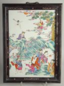 A CHINESE FAMILLE ROSE PORCELAIN PANEL encased within in a hardwood frame, the panel painted with
