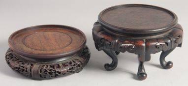 TWO LARGE CHINESE CARVED HARDWOOD VASE STANDS, fitting a base of 14cm diameter, the other 13.5cm