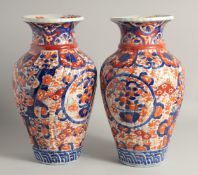A LARGE PAIR OF JAPANESE IMARI VASES, each with ribbed body and painted with foliate decoration,