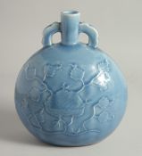A CHINESE BLUE GLAZE TWIN HANDLE PORCELAIN MOON FLASK, with carved flower to the body. 26cm high