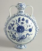 A CHINESE BLUE AND WHITE PORCELAIN TWIN HANDLED MOON FLASK, painted with central floral spray, the