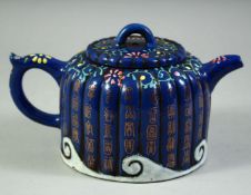 A CHINESE BLUE GLAZED YIXING TEAPOT, the ribbed teapot with characters and floral motifs, the base