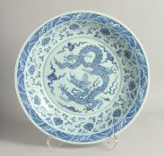 A LARGE CHINESE BLUE AND WHITE PORCELAIN DISH, painted with central dragon, with a border of lotus