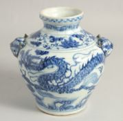 A CHINESE BLUE AND WHITE PORCELAIN TWIN HANDLE VASE, decorated with a dragon and flora, the