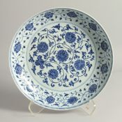 A LARGE CHINESE BLUE AND WHITE PORCELAIN DISH, painted with flower heads and scrolling vine. 33.
