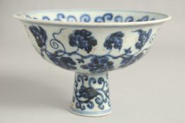A CHINESE BLUE AND WHITE PORCELAIN PEDESTAL BOWL painted with peach, grapes, and scrolling vine.