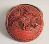 A CHINESE CINNABAR LACQUER CIRCULAR BOX AND COVER, decorated with native flora, the interior and