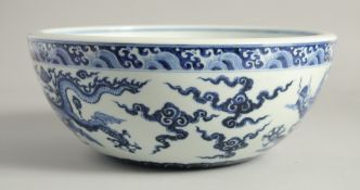 A LARGE CHINESE BLUE AND WHITE PORCELAIN BOWL, the exterior painted with dragons amongst stylised
