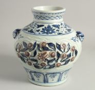 A CHINESE BLUE, WHITE, AND IRON RED PORCELAIN JAR with moulded twin handles and panels of relief