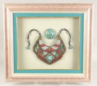 A LARGE DECORATIVE TRIBAL NECKLACE, with applied bead work, pearl and turquoise decoration, framed