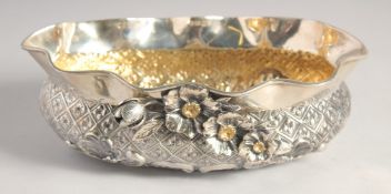 A TURKISH SILVER OVAL SHAPED BOWL, with moulded rim, repousse decoration and applied flower heads,
