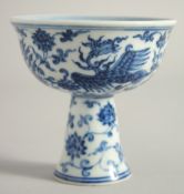 A CHINESE BLUE AND WHITE PORCELAIN STEM CUP decorated with phoenix and lotus, the interior centre