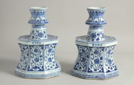 A PAIR OF CHINESE BLUE AND WHITE PORCELAIN CANDLESTICKS each painted with panels of flora and