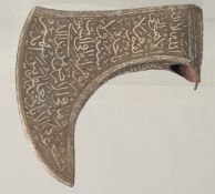 AN ISLAMIC STEEL AXE HEAD, with silver inlaid calligraphy, 21cm at the widest point.