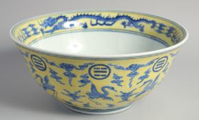 A LARGE CHINESE YELLOW GROUND BLUE AND WHITE PORCELAIN PUNCH BOWL decorated with cranes and dragons.