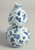 A SMALL CHINESE BLUE AND WHITE PORCELAIN DOUBLE GOURD VASE, decorated with gourds and vine, base