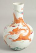 A CHINESE CORAL RED AND WHITE PORCELAIN VASE, painted with a dragon above a carp amongst waves,